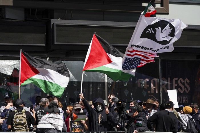 People hold signs and flags protesting the Israel-Hamas war outside of the area that Gal Gadot was honored with a star on the Hollywood Walk of Fame on Tuesday, March 18, 2025 (Photo by Jordan Strauss/Invision/AP)