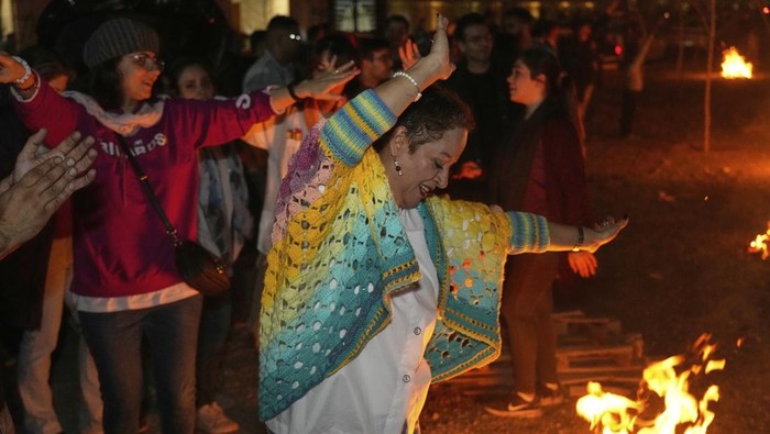 Iranians dance while celebrating Chaharshanbe Souri, or Wednesday Feast, an ancient Festival of Fire on the eve of the last Wednesday of the Persian year, in Tehran, Iran, Tuesday, March 18, 2025. (AP Photo/Vahid Salemi)