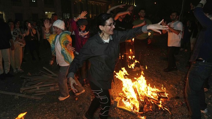 Iranians dance while celebrating Chaharshanbe Souri, or Wednesday Feast, an ancient Festival of Fire on the eve of the last Wednesday of the Persian year, in Tehran, Iran, Tuesday, March 18, 2025. (AP Photo/Vahid Salemi)