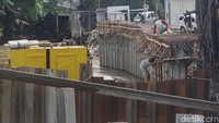 Sejumlah pekerja menyelesaikan pembangunan dinding turap di tepi Sungai Pesanggrahan yang melintas di samping ITC Cipulir, Jakarta, Rabu (9/3/2025).