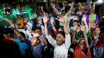 Penduduk desa Jhulasan, yang terletak di distrik Mahesana di negara bagian Gujarat di India barat, berkerumun di samping televisi saat mereka menonton siaran langsung kepulangannya ke bumi, sebelum merayakannya.  