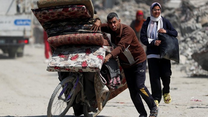 Palestinians make their way to flee their homes, after the Israeli army issued evacuation orders for a number of neighborhoods, following heavy Israeli strikes, in the northern Gaza Strip March 18, 2025. REUTERS/Mahmoud Issa