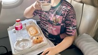 Nah, kalau ini moen Fitri bangga pakai jersey Timnas Indonesia, sambil minum kopi dan ngemil roti di pesawat. Foto: Instagram @fitricarlina