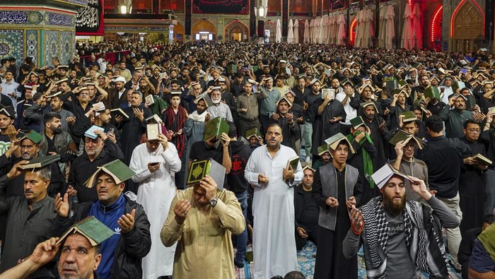 Umat Syiah khusyuk berdoa di makam Imam Ali di Najaf, Irak. Mereka berkumpul untuk menyambut malam Lailatul Qadar.