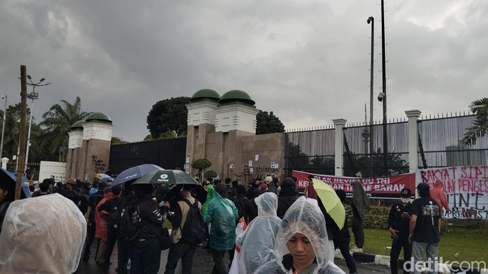 Massa aksi tolak pengesahan RUU TNI masih bertahan di depan gerbang utama Gedung DPR RI, Senayan, Jakarta Pusat, meski hujan mengguyur lokasi. Foto: Fawdi/detikcom.