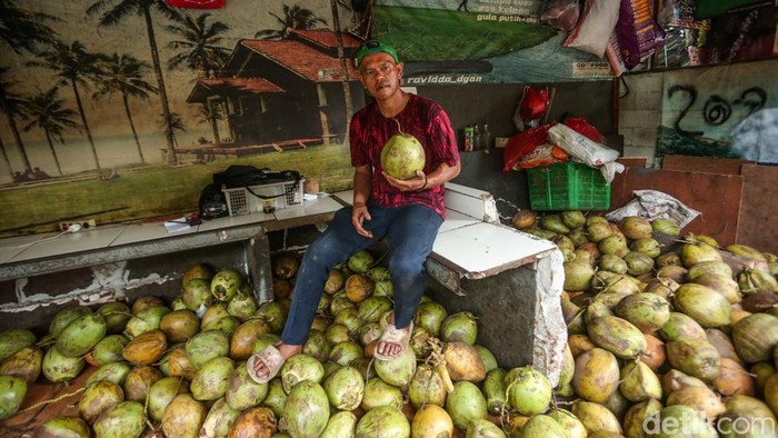 Omzet Naik, Penjual Kelapa Muda Raup Cuan Saat Ramadan Pedagang membuka kelapa muda di Jalan Bangunan Barat, Rawamangun, Jakarta Timur, Kamis (20/3/2025).