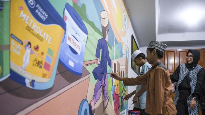 Santri menyelesaikan lukisan mural bertema Ramadhan dalam program Pacific Paint For Bright Life di Pesantren Yayasan Islam Media Kasih, Tangerang, Banten, Kamis (20/3/2025). Kegiatan yang  dilakukan dengan mendonasikan 12.500 liter cat kepada 250 panti asuhan se-Jawa tersebut untuk meningkatkan iklim pendidikan yang lebih menyenangkan bagi para santri. ANTARA FOTO/Galih Pradipta/tom.