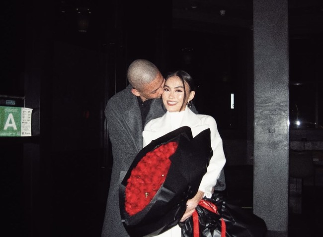 Untuk perayaan anniversary-nya yang keempat, Agnez Mo dan Adam Rosyadi menghabiskan waktu dengan makan malam romantis. Pria yang 13 tahun lebih muda dari Agnez Mo itu menghadiahkan buket bunga mawar merah dan tampak mencium pipinya. Foto: dok. Instagram @agnezmo