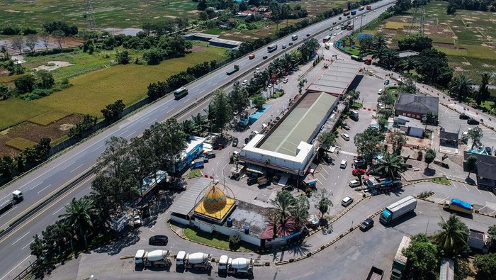 Foto udara kendaraan melintas di samping Rest Area KM 43, Balaraja, Kabupaten Tangerang, Jumat (21/3/2025).  Menjelang arus mudik Lebaran, rest area yang berada di ruas Tol Tangerang - Merak tersebut mulai mendirikan fasilitas pos pengamanan, posko mudik, kantung parkir truk dan Stasiun Pengisian Kendaraan Listrik Umum (SPKLU) untuk memberikan kelancaran serta kenyamanan pemudik.  ANTARA FOTO/Putra M. Akbar/nz