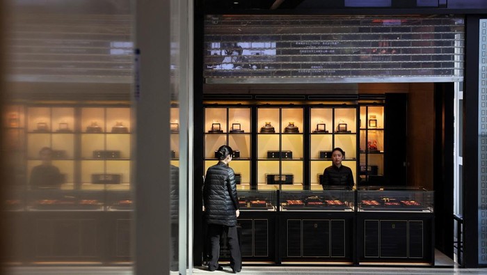 Staff members attend to customers at a Laopu Gold jewellery store in Beijing, China March 12, 2025. REUTERS/Florence Lo