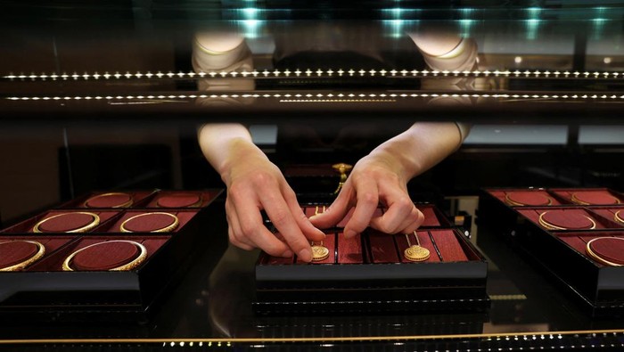 Staff members attend to customers at a Laopu Gold jewellery store in Beijing, China March 12, 2025. REUTERS/Florence Lo