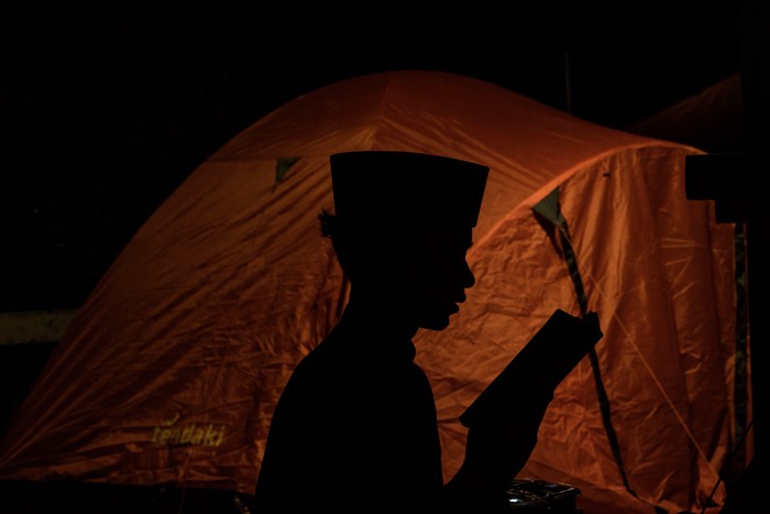 Seorang anak membaca Al Quran saat beriktikaf di Masjid Raya Habiburrahman, Bandung, Jawa Barat, Jumat (21/3/2025) dini hari.Sedikitnya 1500 orang  dari sejumlah daerah di Indonesia mulai mendirikan tenda untuk melaksanakan iktikaf di masjid tersebut pada sepuluh hari terakhir bulan Ramadhan guna mendapatkan malam Lailatul Qadar yang penuh berkah. ANTARA FOTO/Novrian Arbi/nz