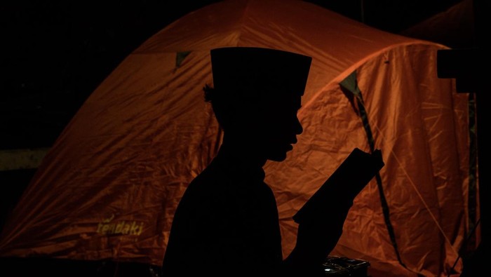 Seorang anak membaca Al Quran saat beriktikaf di Masjid Raya Habiburrahman, Bandung, Jawa Barat, Jumat (21/3/2025) dini hari.Sedikitnya 1500 orang  dari sejumlah daerah di Indonesia mulai mendirikan tenda untuk melaksanakan iktikaf di masjid tersebut pada sepuluh hari terakhir bulan Ramadhan guna mendapatkan malam Lailatul Qadar yang penuh berkah. ANTARA FOTO/Novrian Arbi/nz