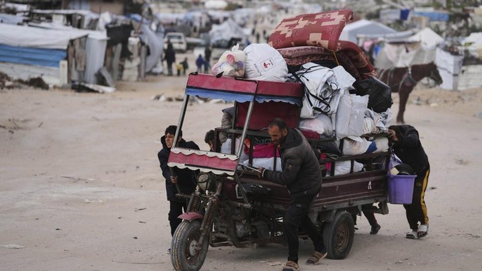 Displaced Palestinians, carrying their belongings, move away from the areas where the Israeli army is operating after Israels renewed offensive in the Gaza Strip, on the outskirts of Beit Lahia, Thursday, March 20, 2025. (AP Photo/Jehad Alshrafi)