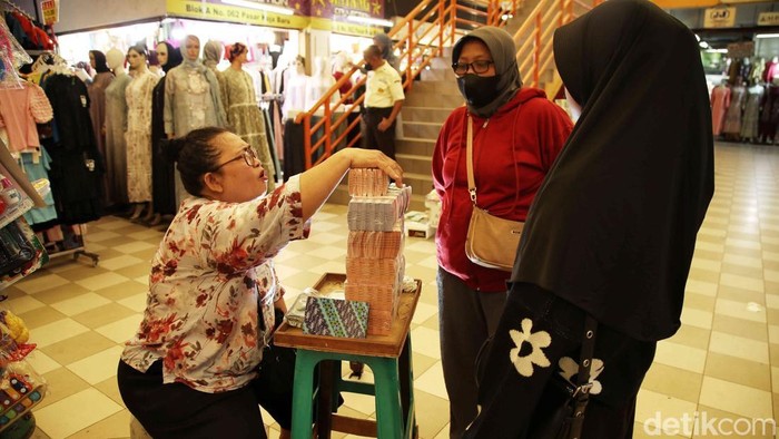 Jelang Lebaran, Jasa Tukar Uang Baru Makin Marak Jasa tukar uang baru melayani pembeli di Pasar Koja, Jakarta Utara, Jumat (21/3/2025).