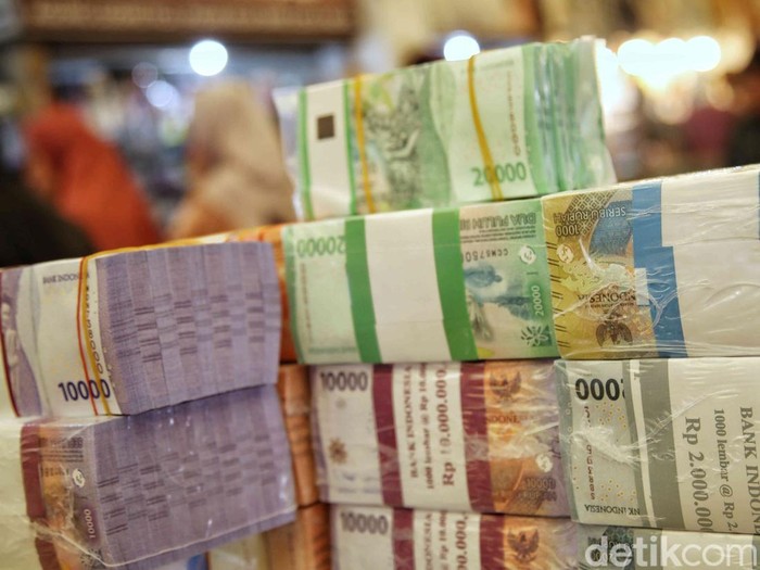 Jasa tukar uang baru melayani pembeli di Pasar Koja, Jakarta Utara, Jumat (21/3/2025).