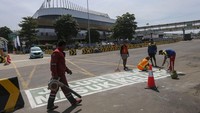 Pekerja menyelesaikan pembuatan marka jalan di Pelabuhan Merak, Kota Cilegon, Banten, Jumat (21/3/2025).