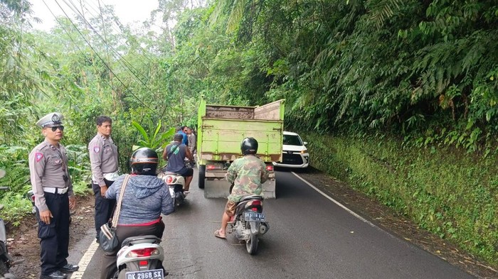 Personel Polsek Selat saat melakukan pengaturan lalu lintas di lokasi truk terperosok ke jurang, Jumat (21/3/2025). (dok. Polsek Selat)
