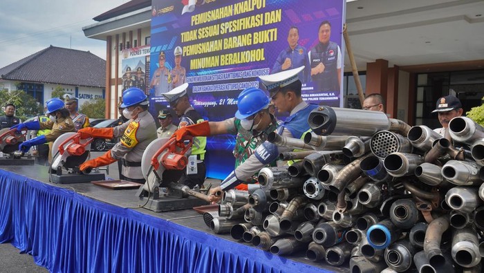 Personel polisi melempar botol minuman keras saat pemusnahan barang bukti minuman keras di Mapolres Temanggung, Jawa Tengah, Jumat (21/3/2025). Dalam kegiatan tersebut jajaran Polres Temanggung memusnahkan sebanyak 2.140 botol miras dan 2.653 knalpot tidak standar guna menciptakan keamanan dan kenyamanan masyarakat selama bulan Ramadhan dan Hari Raya Idul Fitri. ANTARA FOTO/Anis Efizudin/nz