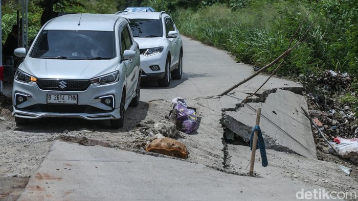 Potret Jalan CBL Cibitung Amblas Jalan Raya Kali CBL, Cibitung, amblas, akibat diguyur hujan deras. Pengendara pun harus melintas bergantian.