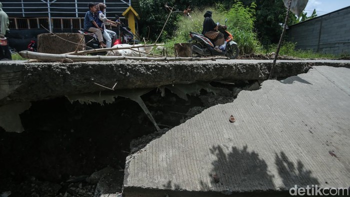 Potret Jalan CBL Cibitung Amblas Jalan Raya Kali CBL, Cibitung, amblas, akibat diguyur hujan deras. Pengendara pun harus melintas bergantian.