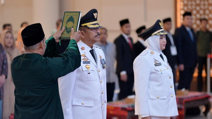 Saipullah Nasution dan Atika Azmi Utammi menjalani pengambilan sumpah jabatan saat dilantik sebagai Bupati dan Wakil Bupati Mandailing Natal (Madina) periode 2025-2030. (Dok. Kominfo Sumut)