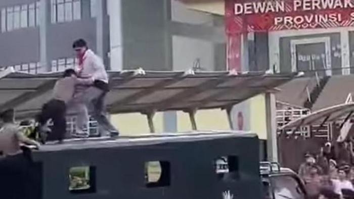 Tangkapan layar mahasiswa dan polisi saling dorong di atap truk dinas Polda Sulut saat demo menolak revisi UU TNI di depan Kantor DPRD Sulut.