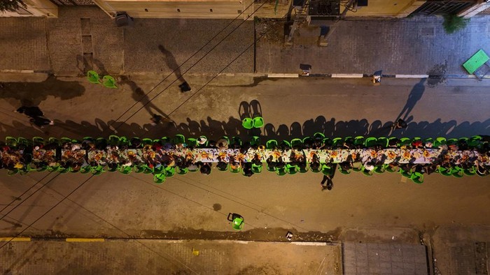 Foto Drone Buka Puasa Bersama di Basra Irak A drone view shows Iraqi orphaned children gathering to break their fast during a free collective Iftar on a street during the holy fasting month of Ramadan, in Basra, Iraq, March 21, 2025. REUTERS/Mohammed Aty TPX IMAGES OF THE DAY