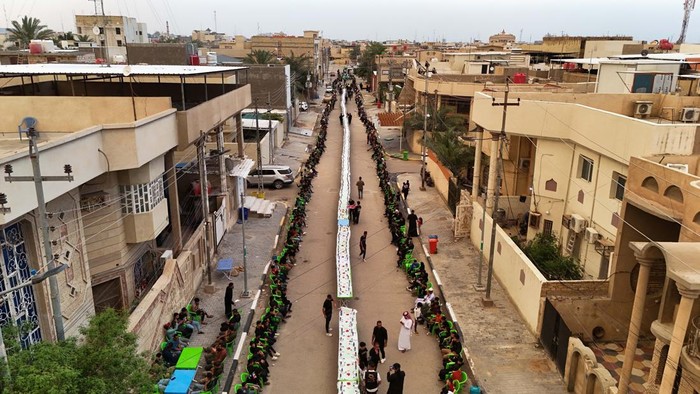 Foto Drone Buka Puasa Bersama di Basra Irak A drone view shows Iraqi orphaned children gathering to break their fast during a free collective Iftar on a street during the holy fasting month of Ramadan, in Basra, Iraq, March 21, 2025. REUTERS/Mohammed Aty TPX IMAGES OF THE DAY