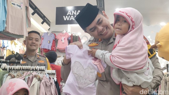 Kapolres Garut AKBP M Fajar saat membelikan baju lebaran untuk dua bocah di Garut