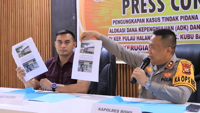 Kapolres Rohil AKBP Isa Imam Syahroni (kanan) dan Kasat Reskrim AKP I Putu Adi Juniwinata saat menunjukkan foto kegiatan yang tak sesuai RAB. (Dok Polres Rohil)