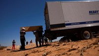 Satu persatu jenazah dikeluarkan dari truk dimakamkan di pemakaman massal di Ciudad Juarez, Meksiko, 21 Maret 2025.