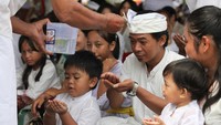 Pemangku memercikkan air suci kepada umat Hindu saat upacara Melasti di Pantai Kenjeran, Surabaya, Jawa Timur, Sabtu (22/3/2025).