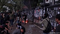 Tak hanya aspal, tembok pagar gedung DPRD Kota Malang juga tak luput dari sasaran aksi corat-coret massa.