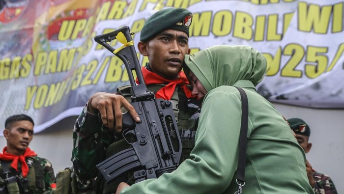 Isak Tangis dan Lambaian Tangan Iringi Keberangkatan TNI ke Papua Seorang prajurit Yonif-732/Banau memeluk istrinya usai mengikuti upacara pemberangkatan Satuan Tugas Pengamanan Perbatasan (Satgas Pamtas) RI-PNG Mobile wilayah Papua di Pelabuhan Ahmad Yani Ternate, Maluku Utara, Minggu (23/3/2025). Sebanyak 450 prajurit Satuan Batalyon Infanteri Yonif-732/Banau tersebut akan bertugas selama sembilan bulan untuk memperkuat pasukan TNI dan Polri yang sudah lebih dulu bertugas menjaga pertahanan dan keamanan di wilayah Papua sekaligus menjalankan tugas menjaga kedaulatan NKRI dengan baik.