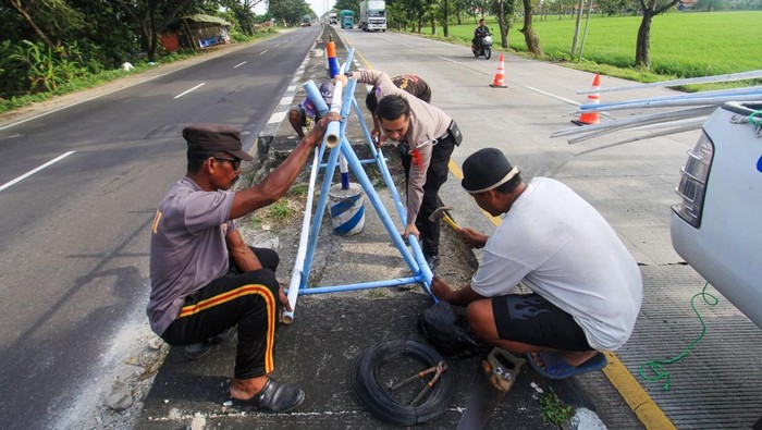 Petugas Satlantas Polres Indramayu bersama sejumlah pekerja memasang pembatas jalan di jalur pantura Lohbener, Indramayu, Jawa Barat, Minggu (23/3/2025). Satlantas Polres Indramayu mulai memasang pembatas jalan yang terbuat dari bambu di jalur mudik sehingga para pemudik bisa melintas jalur pantura dengan lancar dan aman.