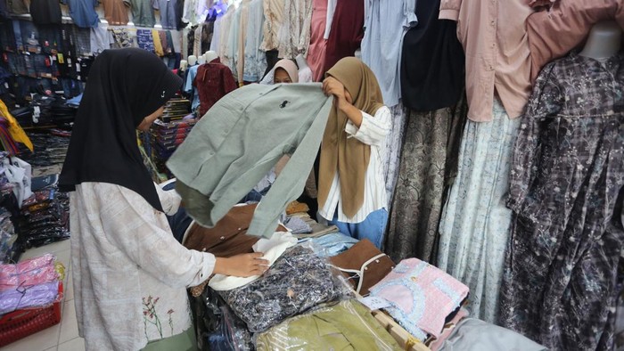 Pedagang melayani pembeli pakaian jadi untuk kebutuhan Lebaran 1446 H di kawasan Pasar Rakyat Meulaboh, Aceh Barat, Aceh, Minggu (23/3/2025). Omzet penjualan berbagai jenis dan merek pakaian jadi untuk kalangan anak-anak, remaja dan dewasa menjelang Lebaran mengalami peningkatan dari biasanya laku Rp2,2 juta per hari menjadi Rp15 juta hingga Rp25 juta per hari. ANTARA FOTO/Syifa Yulinnas/nym.