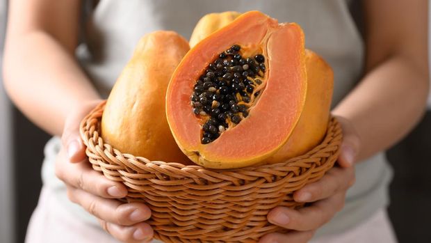 Ripe papaya fruit in a basket holding by woman hand, Tropical fruit