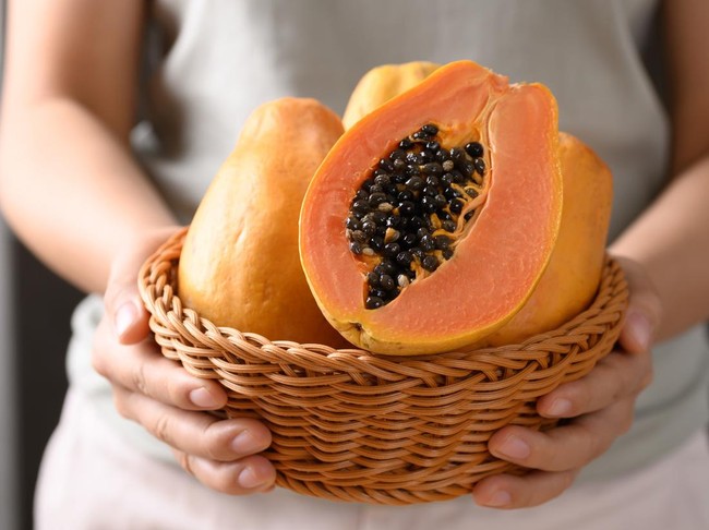 Ripe papaya fruit in a basket holding by woman hand, Tropical fruit
