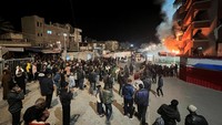 Orang-orang berkumpul saat asap mengepul menyusul serangan udara Israel di rumah sakit Nasser, di Khan Younis, Jalur Gaza, 23 Maret 2025. 