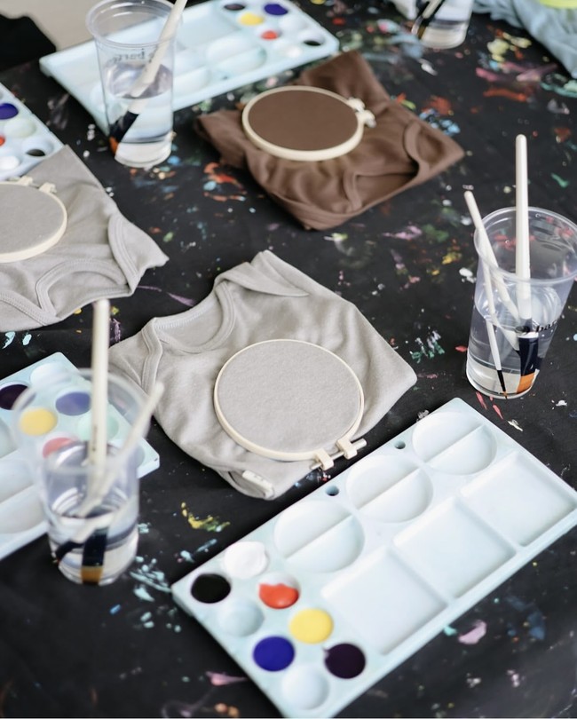 Acara baby shower Clarissa tampak asik dengan beragam aktivitas seru, salah satunya melukis di atas baju bayi. Foto: Instagram/@clarissatanoe