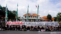 Aksi mereka juga membentangkan spanduk yang dipasang diatas kawat berduri dengan bertuliskan Waspada Kriminalisasi Suporter.
