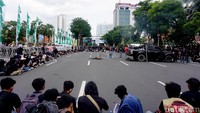 Massa yang membentangkan poster itu membakar ban di tengah jalan. Tampak pagar betis kawat berduri mengeliling depan di depan Gedung Grahadi.
