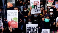 Mahasiswa dan warga bergantian menyerukan penolakan UU TNI. Saat aksi, mereka duduk bersila melingkari ban yang dibakar, tepatnya di depan Grahadi.
