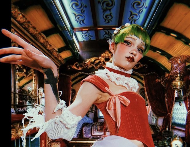 Grimes sering mengubah warna rambutnya menjadi warna-warna mencolok seperti biru neon, hijau terang, dan ungu pastel. Tak hanya itu, ia juga kerap memakai makeup dramatis dengan aksen glitter, garis-garis tajam, dan hiasan wajah yang tampak seperti berasal dari dunia lain.  Foto: dok. Instagram @grimes