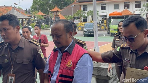 Tersangka NADK yang bekerja sama dengan IMK dalam kasus pemerasan rumah bersubsidi di Buleleng saat di bawa oleh Kejati Bali, Denpasar, Senin (24/3/2025).