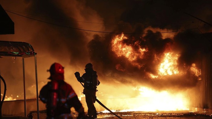 Firefighters extinguish a fire at a factory building that has been engulfed in a wildfire in Uiseong, South Korea, Saturday, March 22, 2025. (Yoon Gwan-shick/Yonhap via AP)