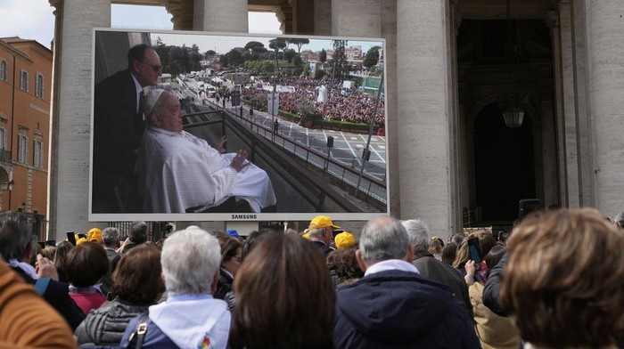 Kondisi Mulai Pulih, Paus Fransiskus Kembali Sapa Ribuan Jemaah Faithful and pilgrims gather in St. Peter's Square at The Vatican to follow on giant screens a live broadcast from Rome's Agostino Gemelli Polyclinic, Sunday, March 23, 2025, where Pope Francis made his first public appearance since he was hospitalized on Feb. 14 with bilateral pneumonia. (AP Photo/Gregorio Borgia)