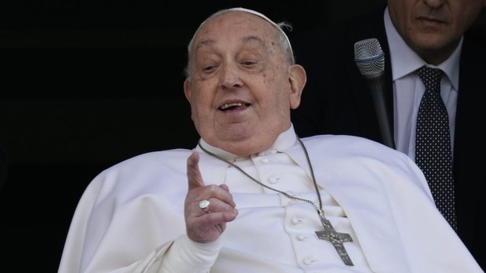 Pope Francis gestures as he appears at a window of the Agostino Gemelli Polyclinic in Rome, Sunday, March 23, 2025, where he has been treated for bronchitis and bilateral pneumonia since Feb. 14. (AP Photo/Domenico Stinellis)