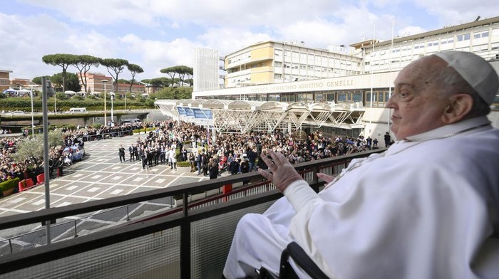Pope Francis waves as he appears at a window of the Agostino Gemelli Polyclinic in Rome, Sunday, March 23, 2025, where he has been treated for bronchitis and bilateral pneumonia since Feb. 14. (Francesco Sforza/Vatican press office via AP)
